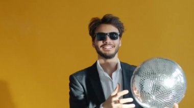 Yavaş hareket eden neşeli melez adam simtopu tutuyor ve dans ediyor.