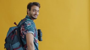 Sırt çantalı, dürbünlü ve gülümseyen karışık ırk yolcularının yavaş hareket eden portresi.