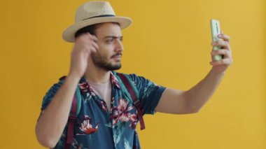 Sırt çantalı Arap turistin akıllı telefon kamerasıyla selfie çektiği yavaş çekim portresi.