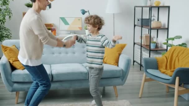 Slow motion av glada familj mor och lille son dansar hemma — Stockvideo