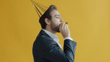 Doğum günü şapkası takan mutlu bir Arap 'ın portresi sarı arka planda tek başına eğleniyor.