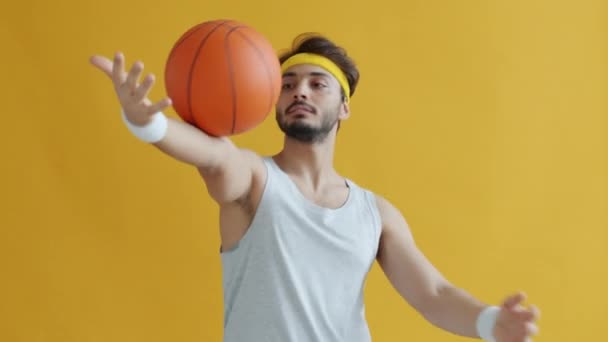 Bonito desportista árabe jogando basquete e olhando para a câmera — Vídeo de Stock