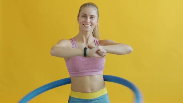 Slow motion porträtt av glad flicka tränar med gymnastiska cirkel och leende — Stockvideo