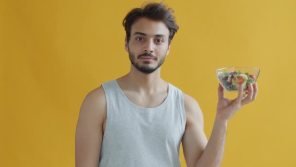 Retrato em câmera lenta de morena do Oriente Médio segurando tigela de salada de legumes e sorrindo — Vídeo de Stock