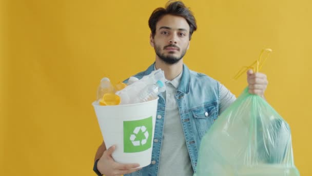 Mladý muž ze Středního východu vybírá plastovou recyklaci místo vyhazování odpadků — Stock video