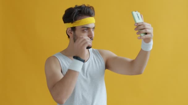 Retrato en cámara lenta del culturista árabe posando para cámara de teléfono inteligente tomando selfie — Vídeos de Stock