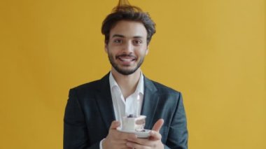 Parti şapkası takan, pastaya mum üfleyen ve gülümseyen Orta Doğulu adamın ağır çekimleri.