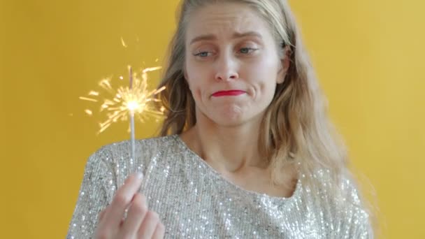Porträtt av olycklig flicka tittar på brinnande tomtebloss och suckande uttrycker negativa känslor — Stockvideo