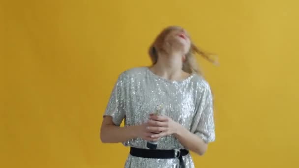 Slow motion van jonge dame dansen het hebben van plezier gooien confetti met popper genieten van vakantie — Stockvideo