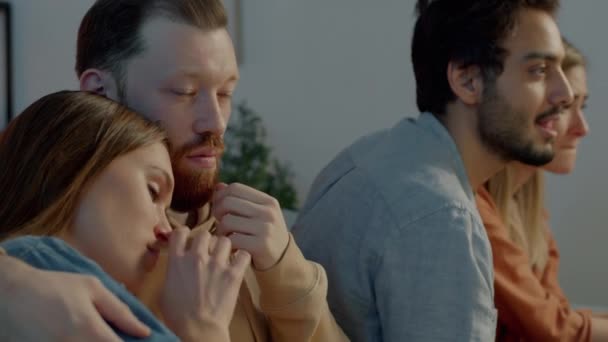 Amigos assistindo filme triste na TV mulheres chorando e homens expressando apoio em casa à noite — Vídeo de Stock