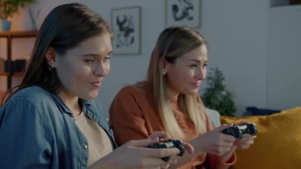 Női barátok szórakozás videojáték játszik, és csinál pacsi otthon este — Stock videók