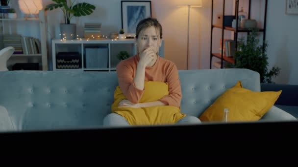 Mujer Joven Asustada Viendo Televisión Frunciendo Ceño Escondiéndose Detrás Almohada — Vídeo de stock
