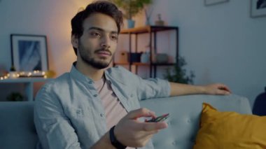 Ortadoğulu biri gece vakti koltukta oturup televizyon izlemekten yoruldu.