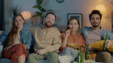 Mutlu gençlik arkadaşlarının portresi TV 'de film seyrediyor ve gülerek evde eğleniyor.