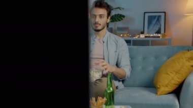 Korkak adam patlamış mısır yiyor sonra da TV 'de son dakika haberlerini izlemekten korkuyor.