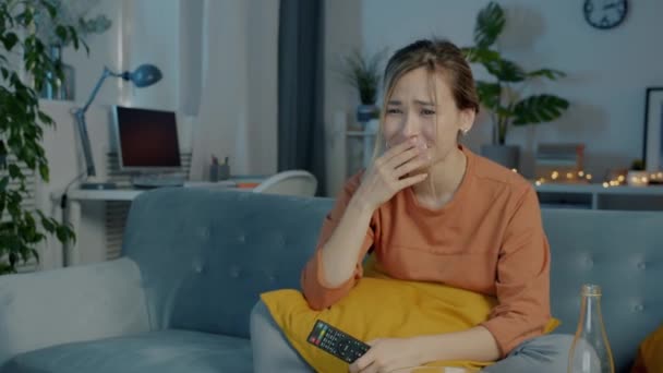 Attrayant jeune femme regarder le drame à la télévision exprimant l'empathie assis sur le canapé dans la maison sombre — Video