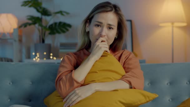 Портрет сумної молодої жінки, що дивиться мелодраму по телевізору в темній квартирі ввечері — стокове відео