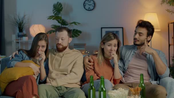 다양 한 사람들 이 TV 를 보고 있는 행복 한 친구들은 밤에 어두운 집에서 카메라를 보고 울고 있다 — 비디오