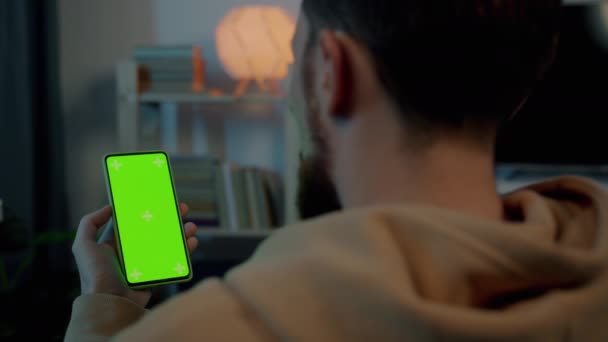 밤에 집에서 녹색 색차 키 폰 스크린을 보고 있는 젊은 남자의 어깨 사진 이상 — 비디오