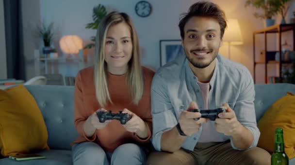 Retrato de alegre hombre y mujer jugando videojuego divirtiéndose en apartamento por la noche — Vídeo de stock