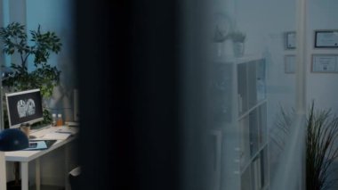 Ofiste akıllı telefon kullanan bir erkek doktor. Sonra karanlık hastanedeki MRI taramalarına bakmak için bayan meslektaşıyla buluşuyor.