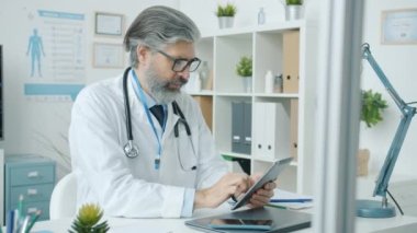 Ofiste çalışan beyaz önlüklü bir doktorun portresi.