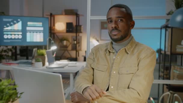 Portrait au ralenti d'un employé masculin assis au bureau dans un bureau moderne le soir — Video