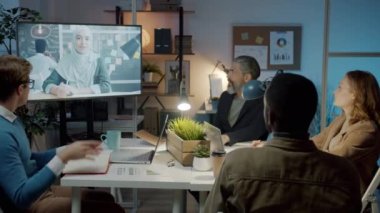 Gece geç saatlerde karanlık ofiste iş arkadaşlarıyla konuşuyorlar.