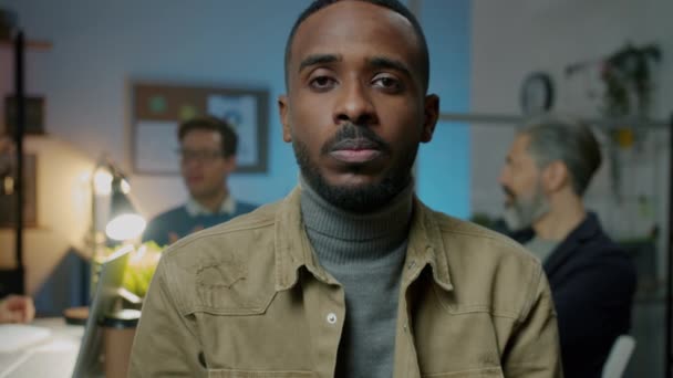 Retrato de empresario afroamericano discutiendo negocios durante reunión virtual en oficina oscura — Vídeo de stock