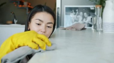 Güzel Asyalı ev kadınının portresi. Mutfağı ıslak bezle temizliyor. Modern bir dairede ev işi yapıyor.