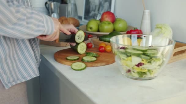 Nahaufnahme weiblicher Hände mit Messer, das frisches Gemüse schneidet und in der heimischen Küche Salat zubereitet — Stockvideo