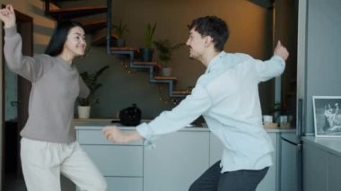 Mutfakta dans eden genç adam ve kadının yavaş çekimleri.