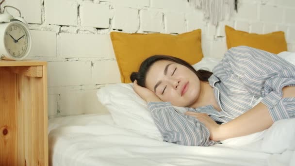 Retrato de una hermosa dama asiática durmiendo en la cama sola usando pijama — Vídeos de Stock