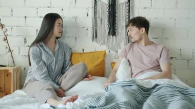 Kızgın gençler evde yatakta sorunları tartışırken kavga ediyorlar.