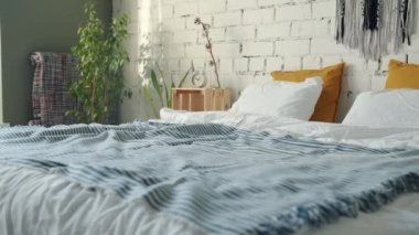 Çatı katı tarzı ve mobilyası olan rahat bir yatak odası ve hiç insan yok.