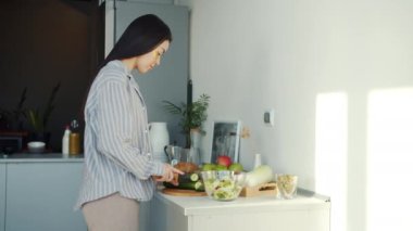 Asyalı ev kadınının portresi mutfakta sebze salatası pişiriyor.