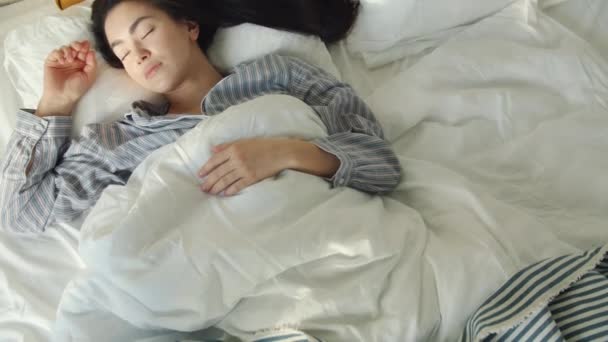 Top vista de lindo asiático estudiante durmiendo en cómoda cama acostado solo con los ojos cerrados disfrutando del descanso. — Vídeo de stock