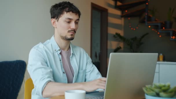 Retrato del freelancer exitoso que habla por teléfono móvil y usa una computadora portátil que trabaja en casa — Vídeo de stock