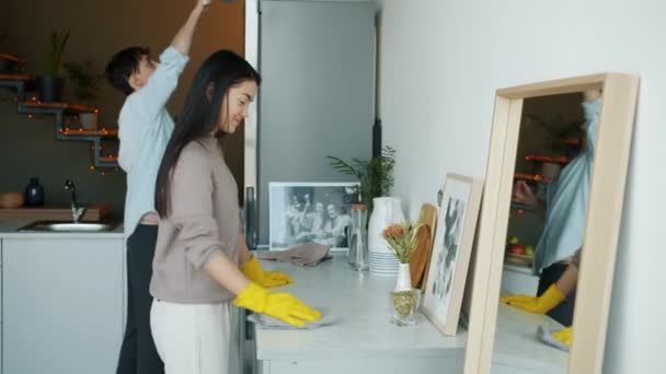 Chłopak i dziewczyna sprzątanie domu i taniec zabawy w mieszkaniu razem — Wideo stockowe