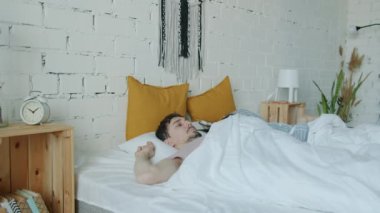 Uyuyan adam ve kız evde uyanıp yatak odasından aceleyle çıkıyorlar işe geç kalıyorlar.