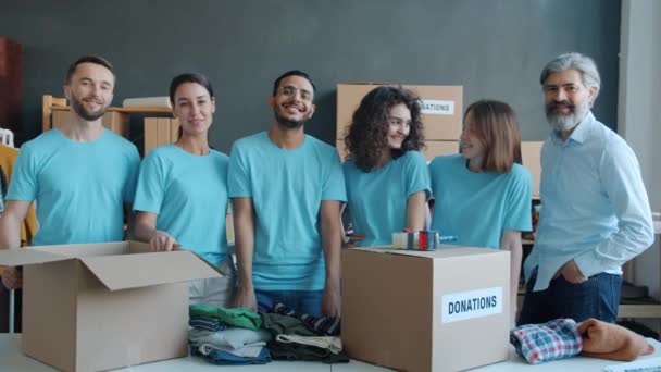 慈善机构员工慢动作的肖像 站在捐款箱里 微笑着看着办公室里的相机 人与志愿工作概念 — 图库视频影像