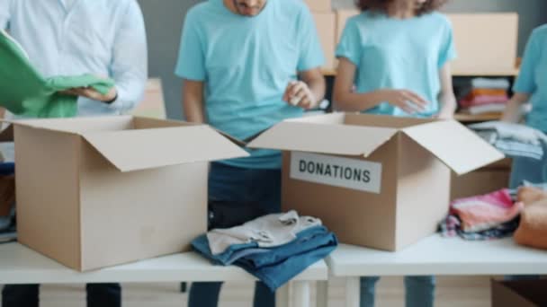 Primer Plano Cajas Para Donación Voluntarios Uniforme Empacando Ropa Oficina — Vídeo de stock