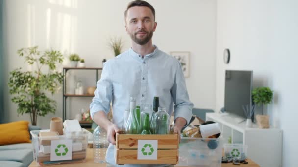 Vrolijke Jongeman Die Een Recyclingcontainer Vasthoudt Met Flessen Die Alleen — Stockvideo