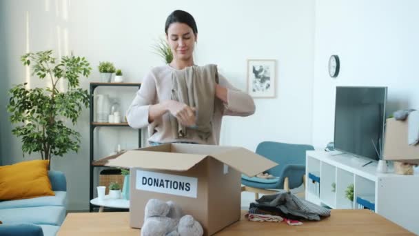 Ung Kvinde Indsamler Tøj Til Donation Mens Mand Datter Hjælper – Stock-video