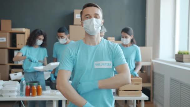 Arkadaşları Bağış Için Yiyecek Toplarken Yardım Fonu Ofisinde Duran Maskeli — Stok video