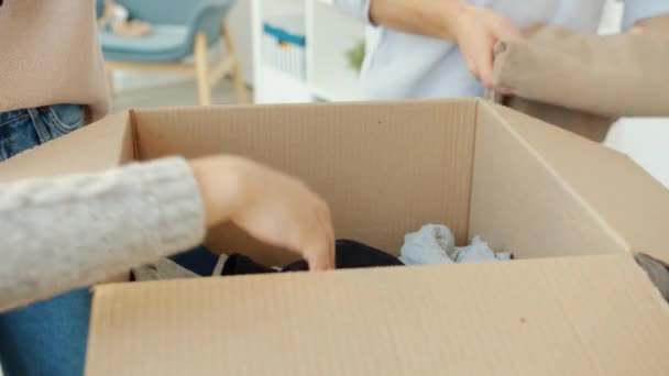 Close Mãos Adulto Criança Coletando Roupas Para Doação Colocando Caixa — Vídeo de Stock