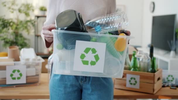 プラスチック容器と家庭でそれを保持する女性との完全なリサイクルボックスのクローズアップ 環境保全と汚染の概念 — ストック動画