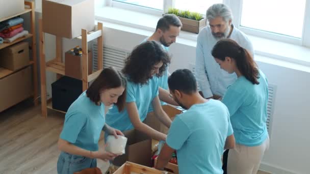 一群身穿制服 用集装箱包装食物的慈善工作者一起在现代办公室工作 合作与志愿服务概念 — 图库视频影像