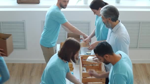 Voluntários Homens Mulheres Embalando Alimentos Recipientes Para Doação Que Trabalham — Vídeo de Stock