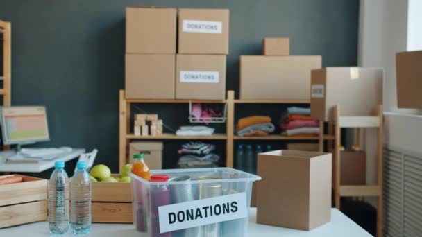 Büro Einer Wohltätigkeitsorganisation Mit Lebensmittelcontainern Und Gebrauchter Kleidung Den Regalen — Stockvideo